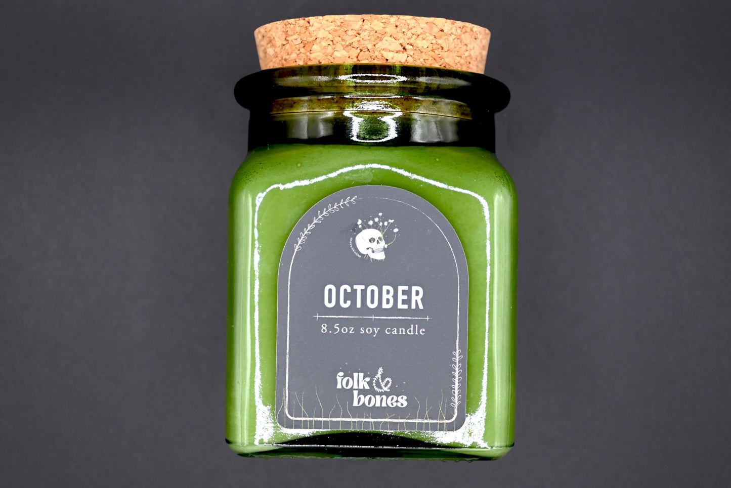 Folk and Bones October 8 oz soy candle in a glass jar with an autumn-inspired label and warm, inviting glow.