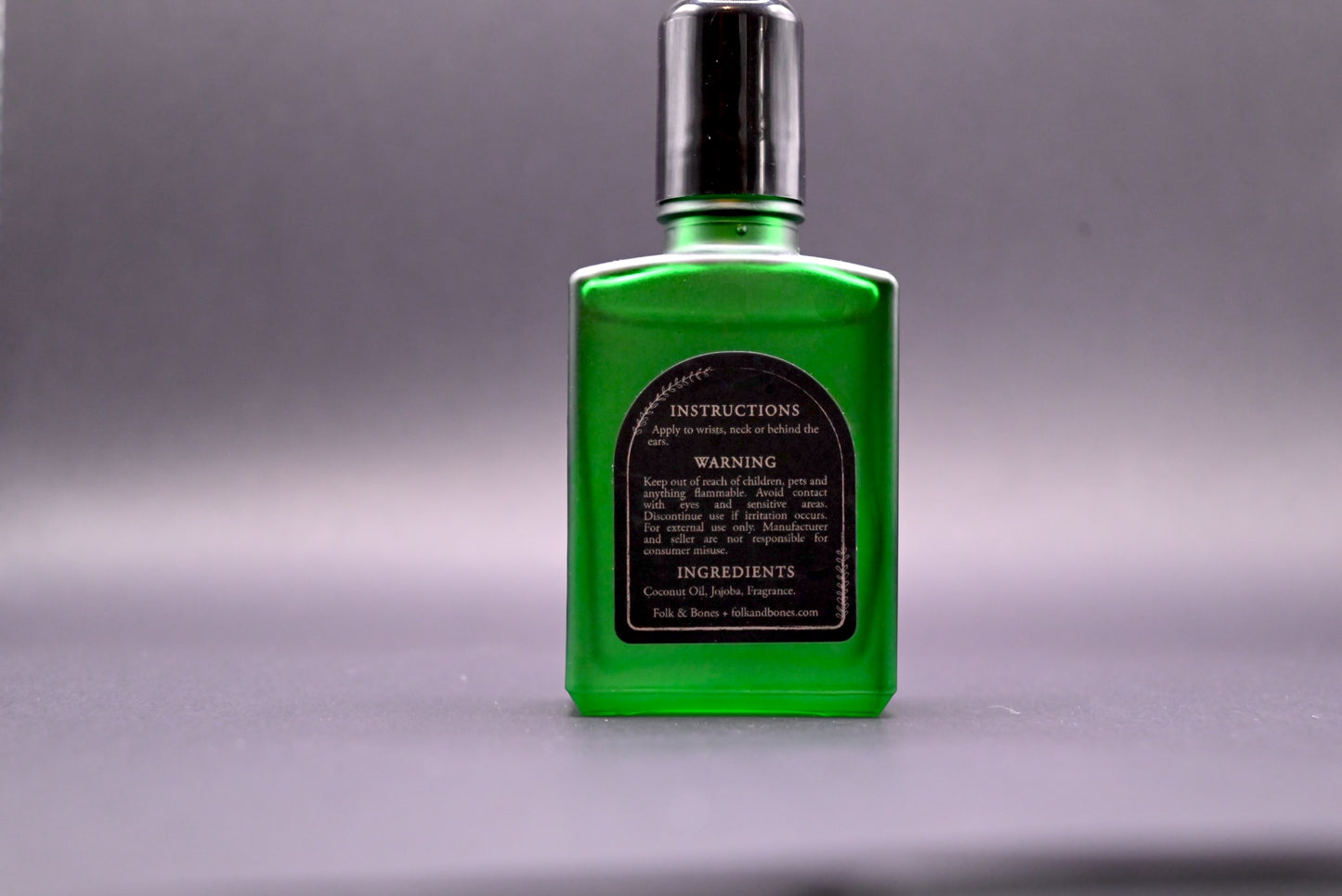 Folk and Bones Ghostly 1 oz perfume oil candles with ghostly-themed design in a glass container, featuring a dark, mysterious aesthetic.