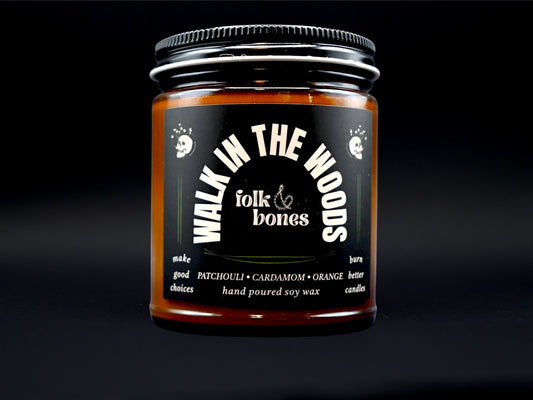 Folk and Bones Walk in the Woods 8 oz soy candle featuring a rustic jar with a nature-inspired label and wooden lid.