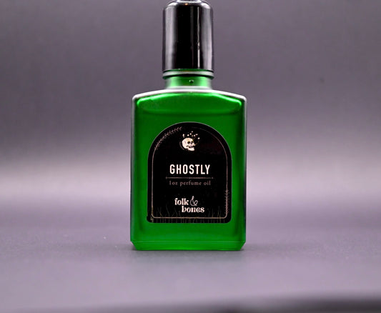 Folk and Bones Ghostly 1 oz perfume oil bottle with black cap, displayed on a neutral surface.