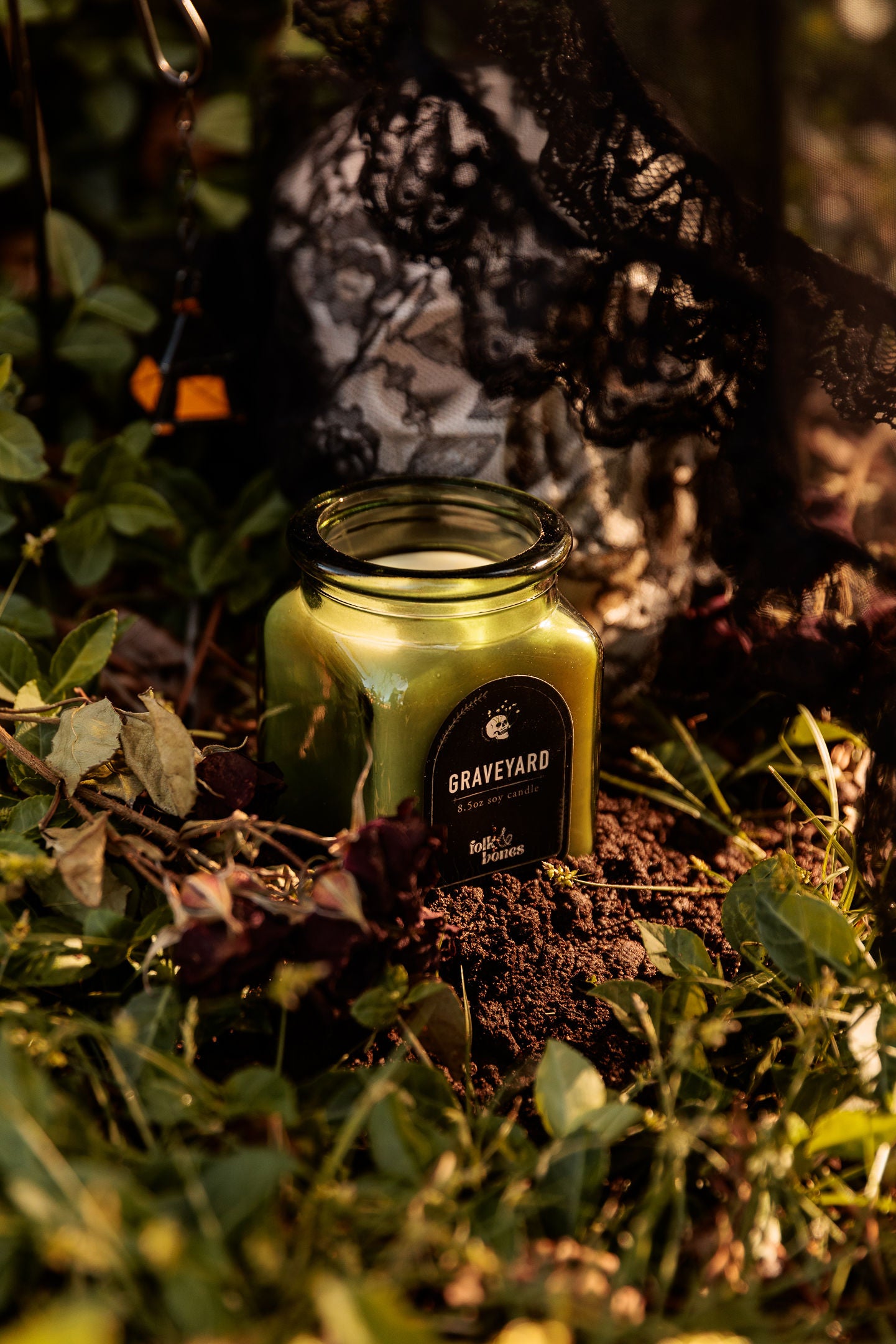 Folk and Bones Graveyard 8 oz soy candle with dark label and lid, ideal for gothic or spooky decor.