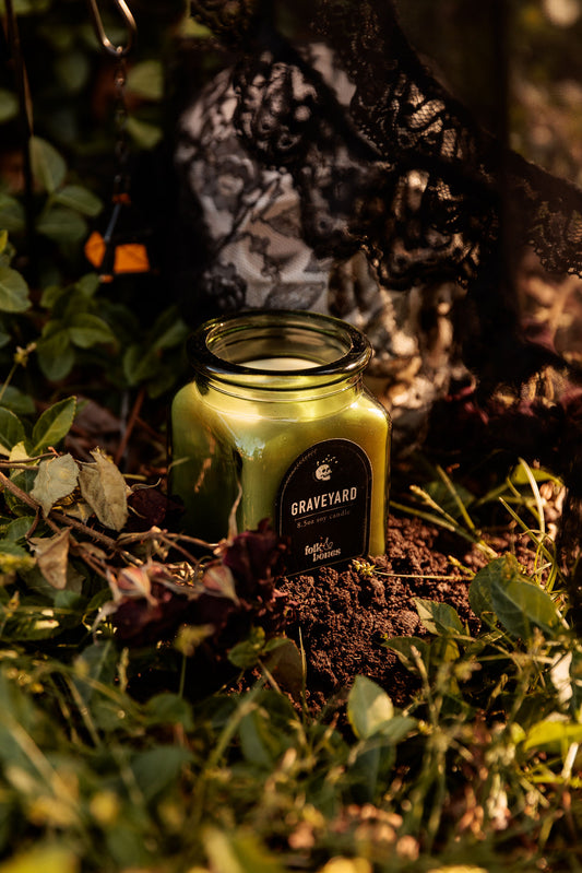 Folk and Bones Graveyard 8 oz soy candle with dark label and lid, ideal for gothic or spooky decor.