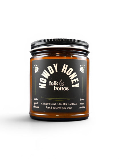 Folk and Bones Howdy Honey 8 oz soy candle with a rustic jar and a lit wick, showcasing warm, inviting candlelight.