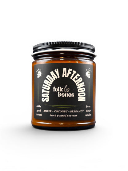 Folk and Bones Saturday Afternoon 8 oz soy candle with a simple, elegant white wax exterior and a wooden wick.