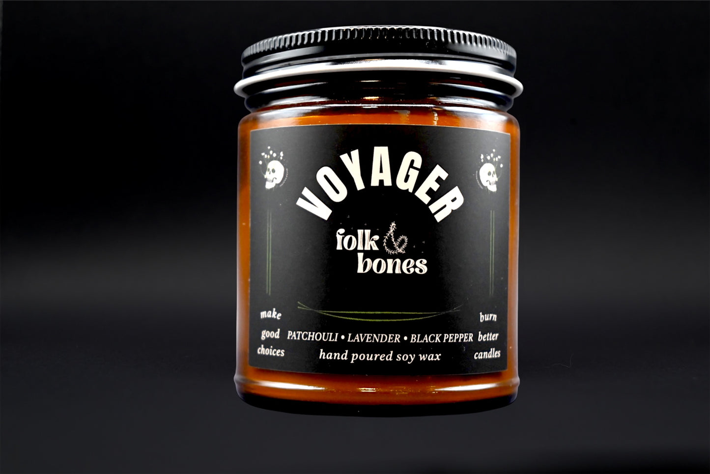 Folk and Bones Voyager 8 oz soy candle in a glass jar with a lit wick and minimalist label on a neutral background.