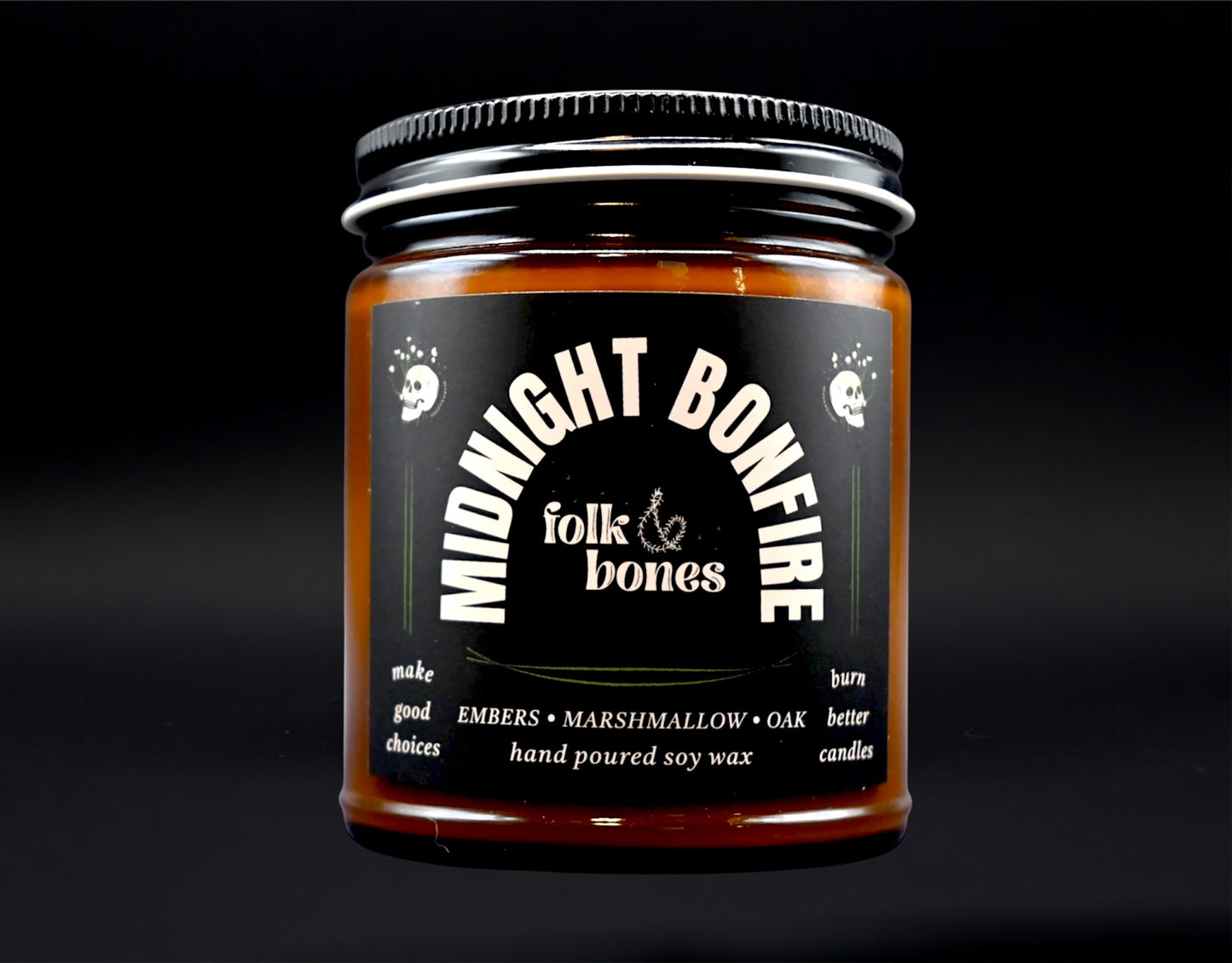 Folk and Bones Midnight Bonfire 8 oz soy candle in a glass jar with a black lid, showing the candle's dark wax and wooden wick.