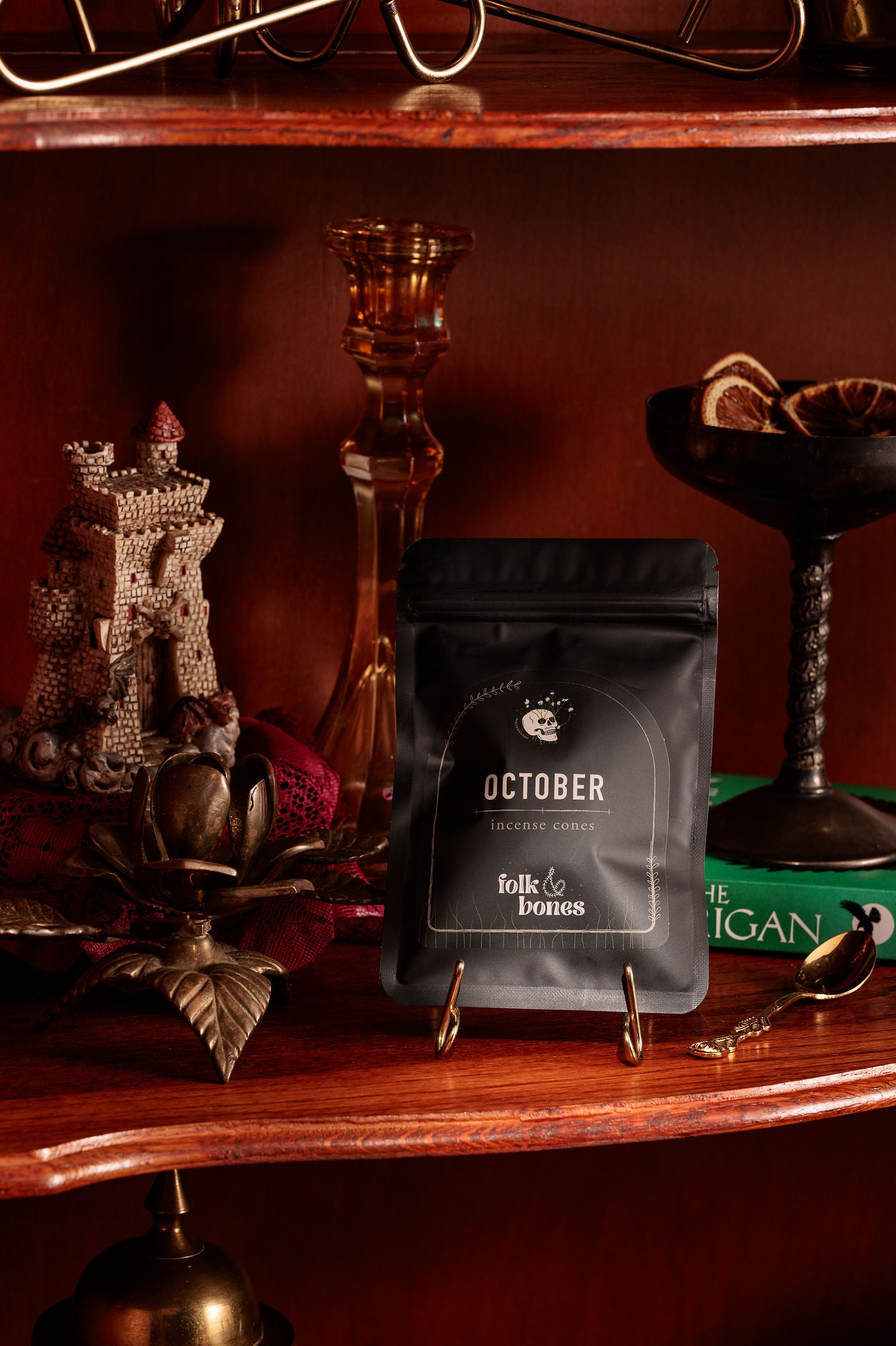 Folk and Bones October incense cone candles in a decorative box, showcasing dark autumn-themed packaging and cone-shaped candles.