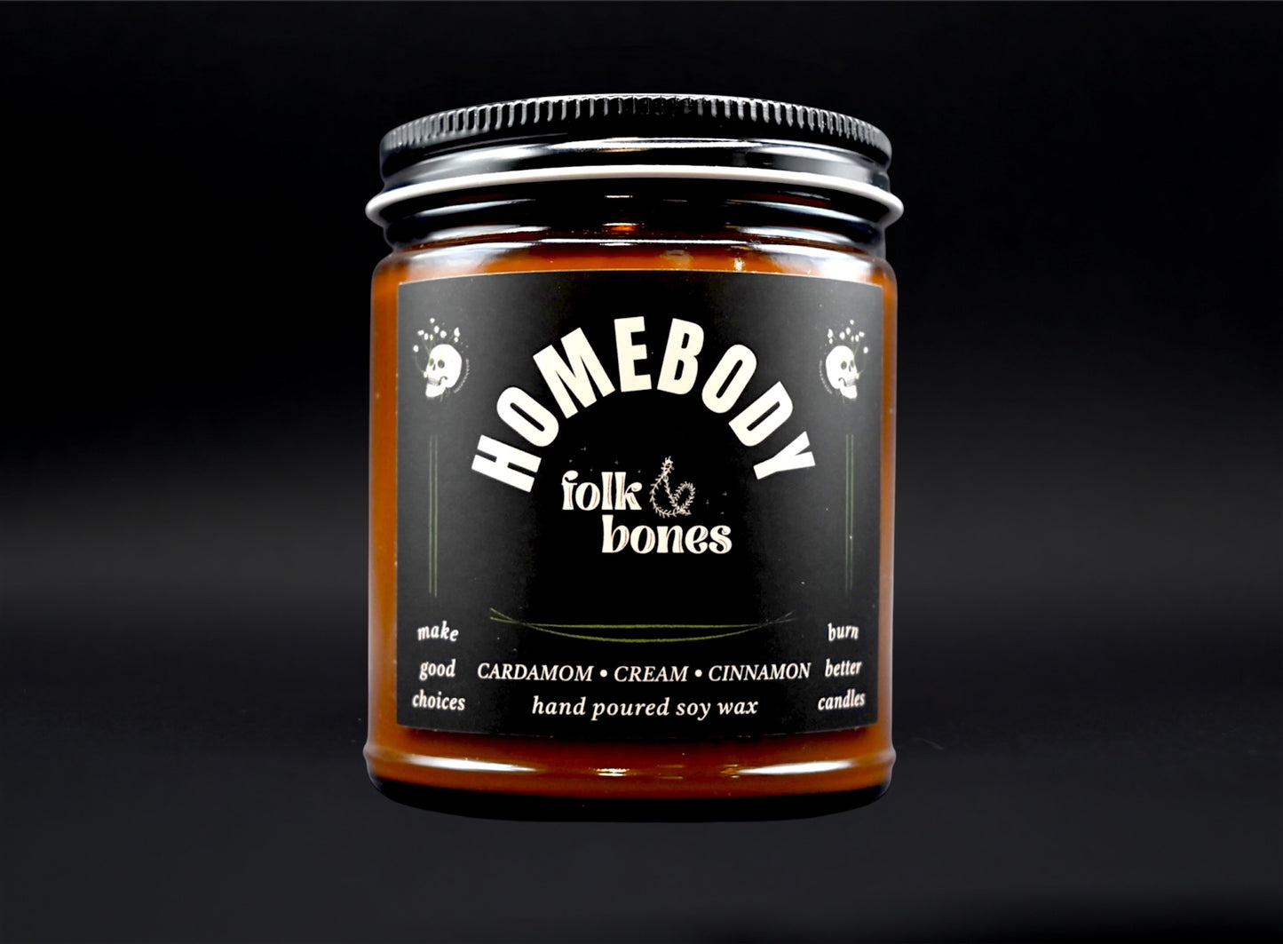 Folk and Bones Homebody 8 oz soy candle in a glass jar with a wooden lid, warm amber glow and clean-burning wick.