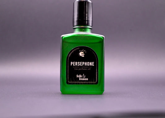 Folk and Bones Persephone 1 oz perfume oil bottle with dark label, displayed on a neutral background.