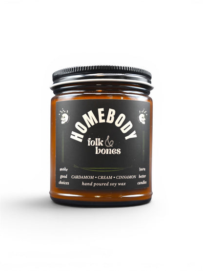 Folk and Bones Homebody 8 oz soy candle in a glass jar with a wooden lid, showcasing a cozy, minimalist design.