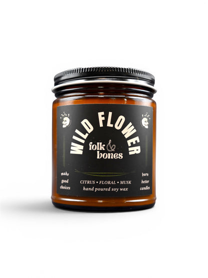 Folk and Bones Wild Flower 8 oz soy candle in a glass jar with a floral scent and a natural, rustic design.