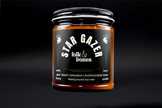 Folk and Bones Stargazer 8 oz soy candle with a sleek jar, featuring a starry night design and a warm, inviting glow.