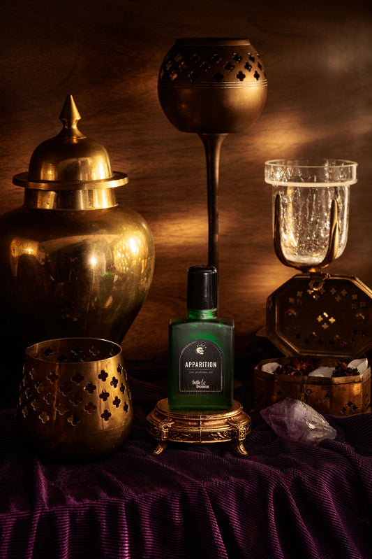Folk and Bones Apparition 1 oz perfume oil candle with dark, mystical wax and botanical accents in a glass jar.