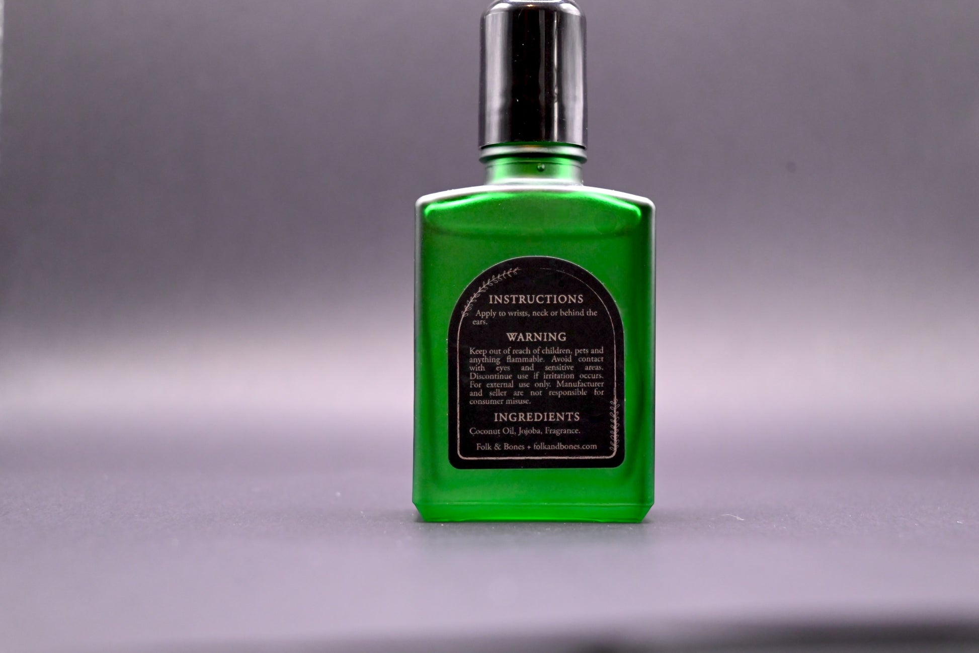 Folk and Bones Ghostly 1 oz perfume oil candles with ghostly-themed design in a glass container, featuring a dark, mysterious aesthetic.