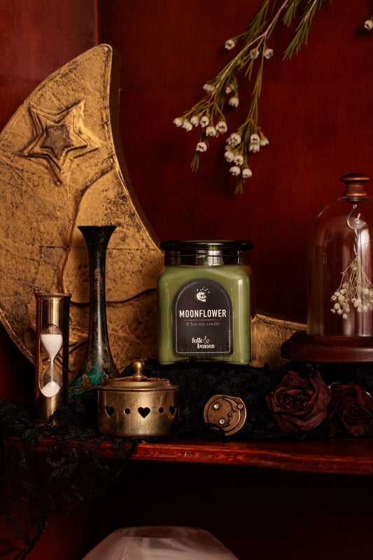 Folk and Bones Moonflower 8 oz soy candle with a white wax finish and wooden wick, romantic floral scent visible in a glass jar