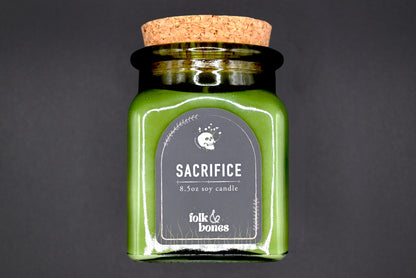 Folk and Bones Sacrifice 8 oz soy candle in a glass jar with a natural wax finish, ideal for home decor and aromatherapy.