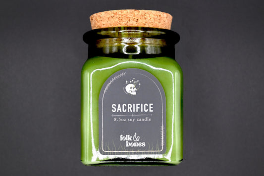 Folk and Bones Sacrifice 8 oz soy candle in a glass jar with a natural wax finish, ideal for home decor and aromatherapy.