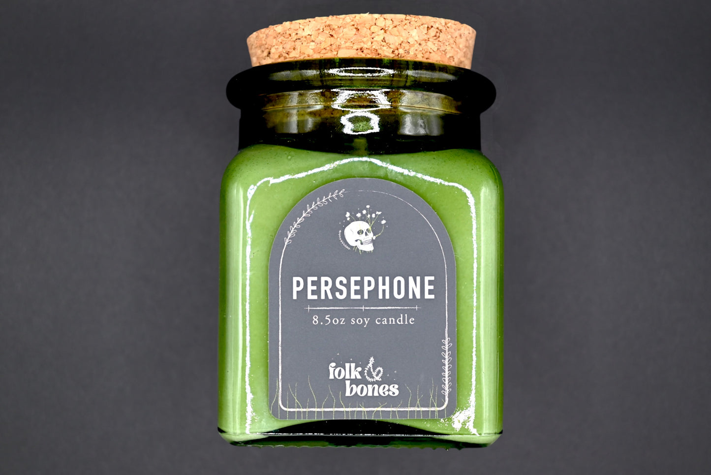 Persephone 8 oz soy candle by Folk and Bones, showing a lit candle in a glass jar with a minimalist label design.
