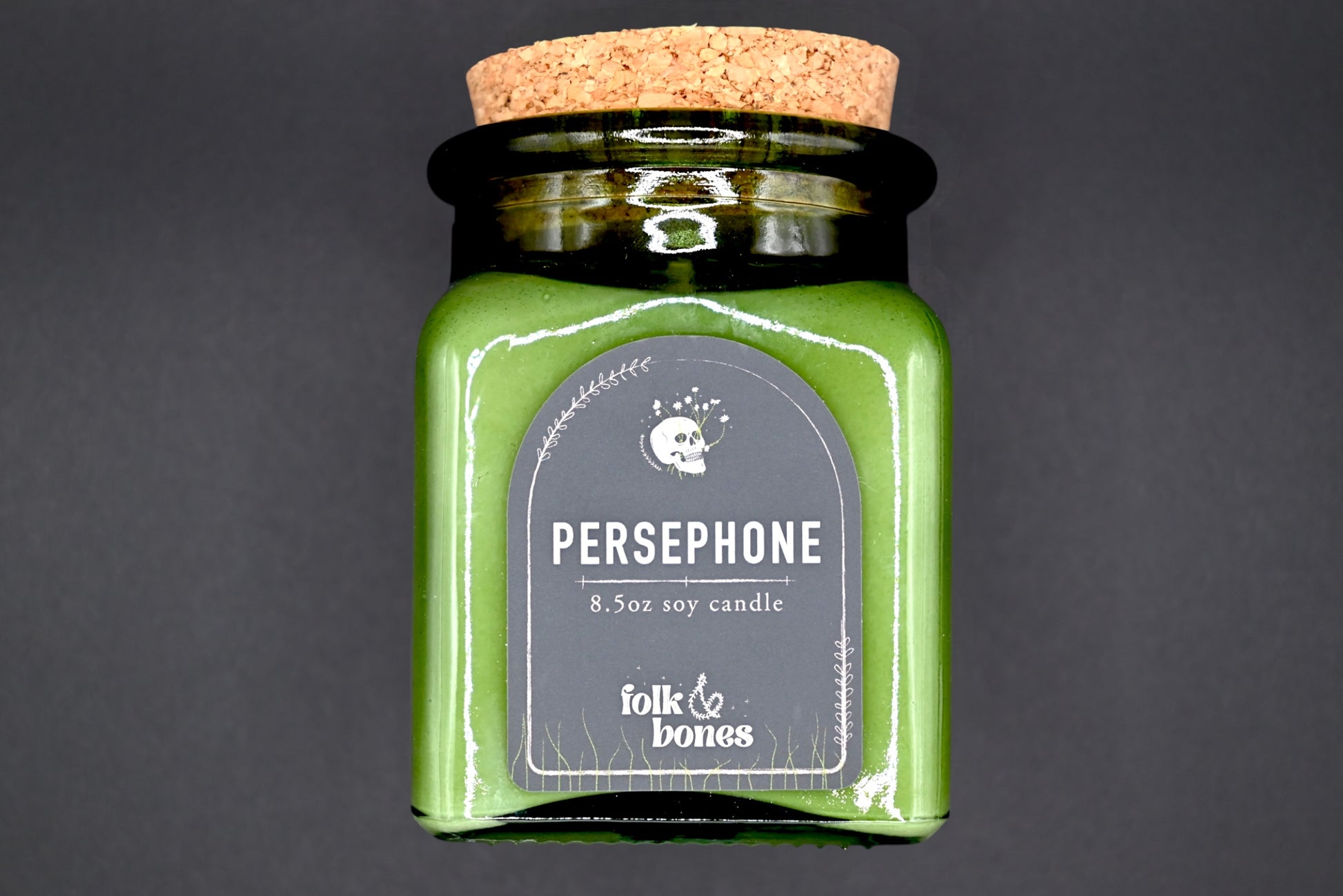 Persephone 8 oz soy candle by Folk and Bones, showing a lit candle in a glass jar with a minimalist label design.