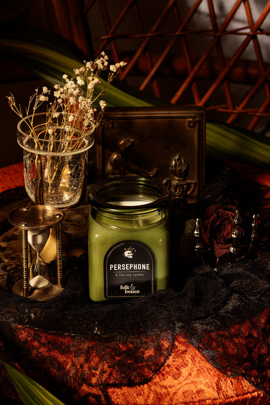 Persephone 8 oz soy candle by Folk and Bones, showing a white candle in a glass jar with a minimalist label design.