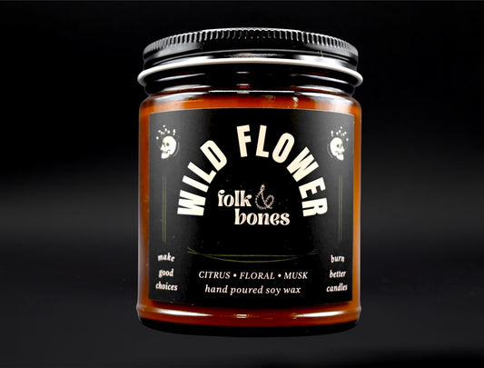 Folk and Bones Wild Flower 8 oz soy candle with a rustic glass jar and a natural floral label, perfect for home décor and ambiance.