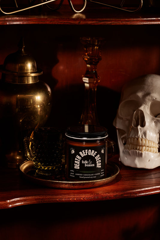 Folk and Bones Death Before Decaf soy candle in an 8 oz jar with a black and white label, unlit and ready for use.