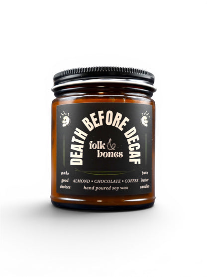 Folk and Bones Death Before Decaf soy candle in an 8 oz glass jar with a lit wick and minimalist label design.