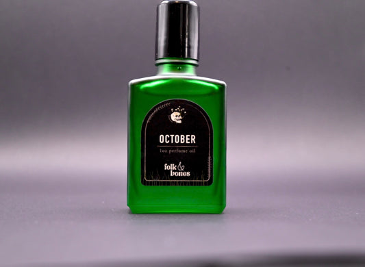 Folk and Bones October 1 oz perfume oil candle with a sleek, dark glass container and minimalist label.