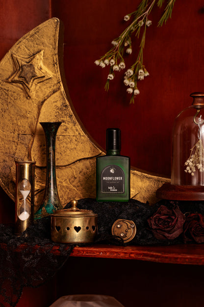 Folk and Bones Moonflower 1 oz perfume oil bottle with a silver cap and floral label, placed on a neutral background