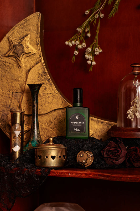 Folk and Bones Moonflower 1 oz perfume oil bottle with a silver cap and floral label, placed on a neutral background